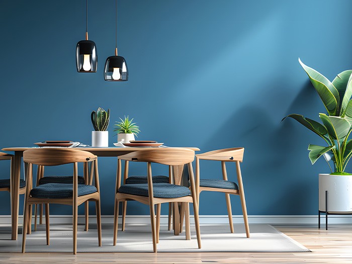 Blue accent wall sets the background for a wood dining set.